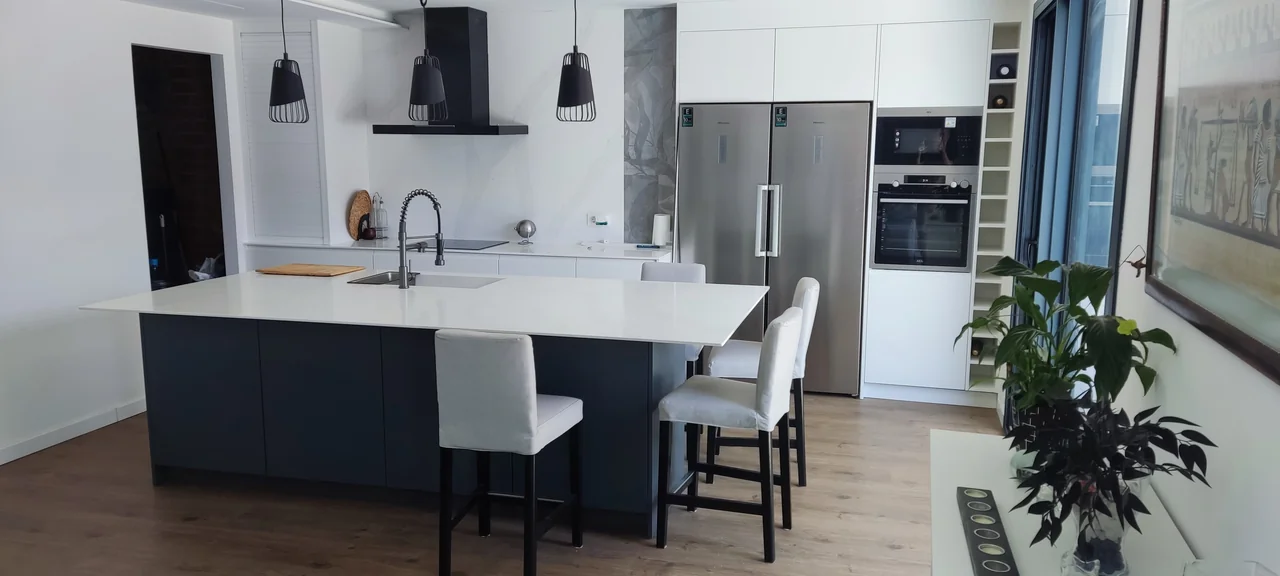 Cocina con isla y mobiliario blanco